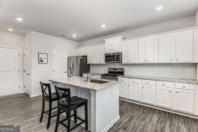 kitchen with white cabinetry, a sink, stainless steel appliances, and dark wood finished floors