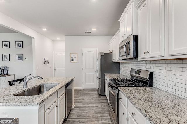 kitchen with a sink, white cabinetry, an island with sink, and appliances with stainless steel finishes