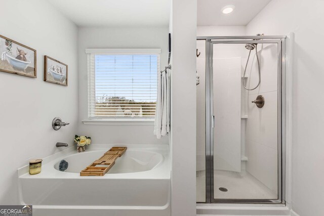 full bathroom featuring a bath and a stall shower