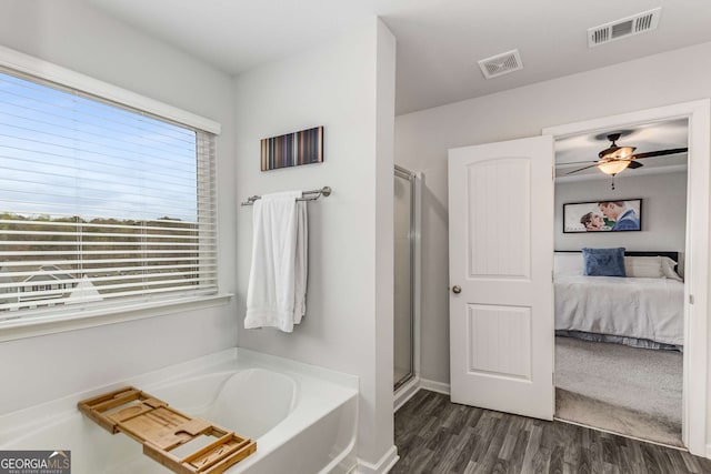 ensuite bathroom with wood finished floors, ensuite bathroom, a garden tub, and visible vents