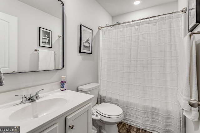 bathroom with curtained shower, toilet, vanity, and wood finished floors