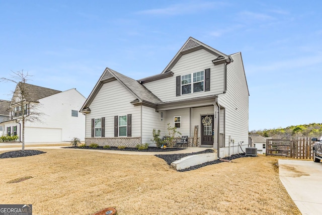 view of front facade featuring driveway, central AC unit, and fence
