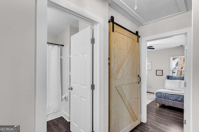 2072 Baker Rd NW, Atlanta, GA 30318 - hallway featuring a barn door, baseboards, attic access, and dark wood finished floors