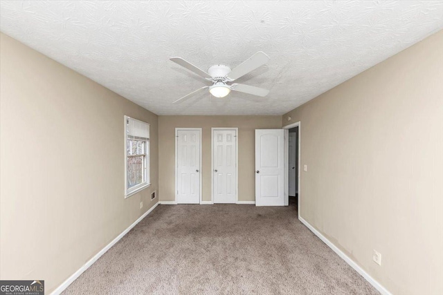 1736 Salem Woods Dr SE, Conyers, GA 30013 - unfurnished bedroom with ceiling fan, carpet, baseboards, and a textured ceiling
