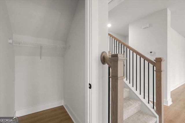 stairway with wood finished floors and baseboards