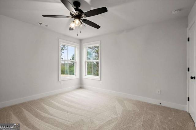 carpeted spare room with a ceiling fan, baseboards, and visible vents