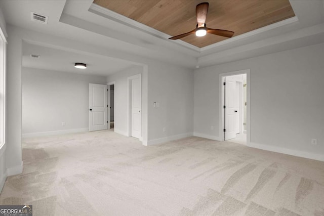 spare room featuring a ceiling fan, baseboards, visible vents, a tray ceiling, and wooden ceiling