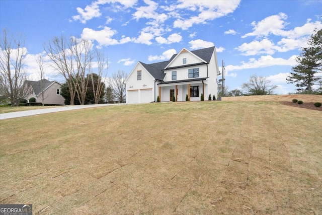 view of front facade featuring covered porch, driveway, an attached garage, and a front yard