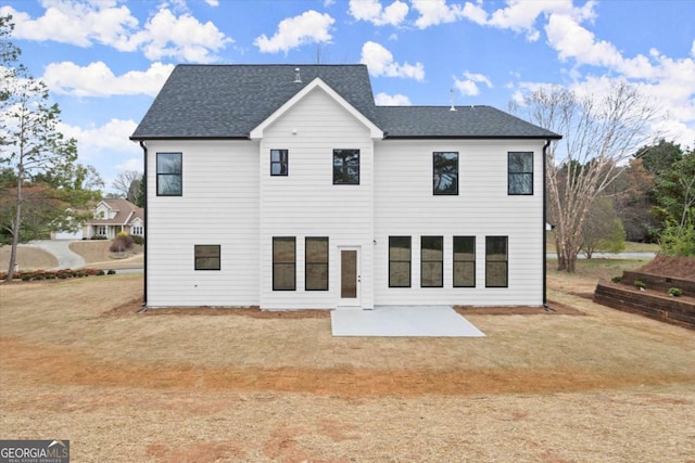 back of property featuring roof with shingles and a patio area