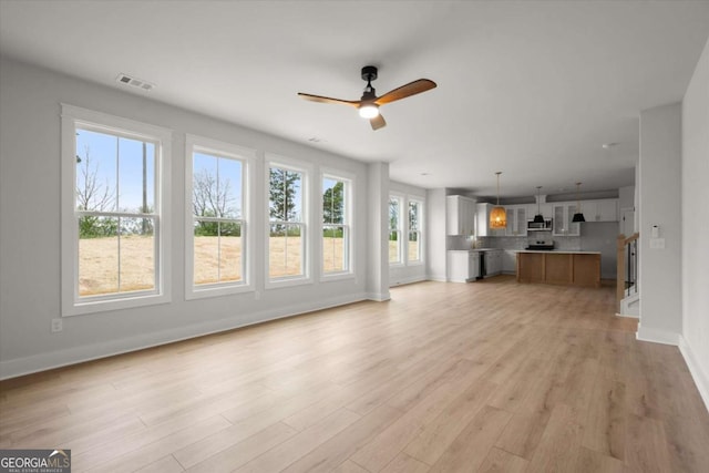 unfurnished living room with baseboards, a ceiling fan, visible vents, and light wood-type flooring
