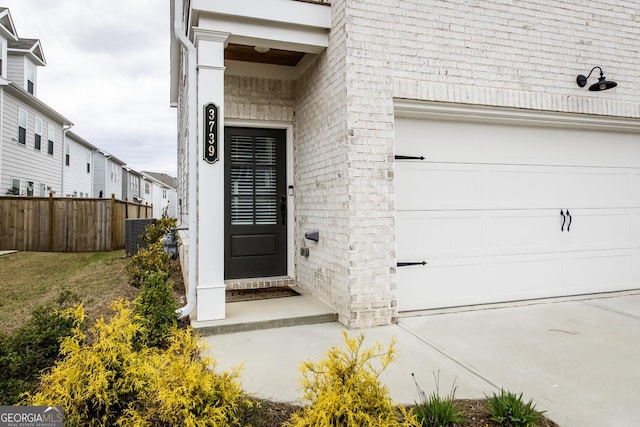 3739 Silvery Way, Powder Springs, GA 30127 - property entrance featuring a garage, brick siding, cooling unit, and fence