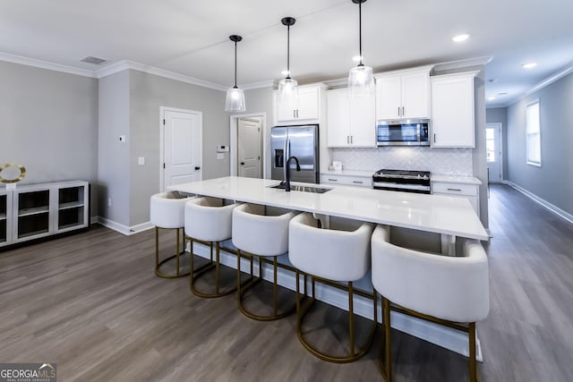 3739 Silvery Way, Powder Springs, GA 30127 - kitchen with an island with sink, a sink, white cabinets, appliances with stainless steel finishes, and backsplash