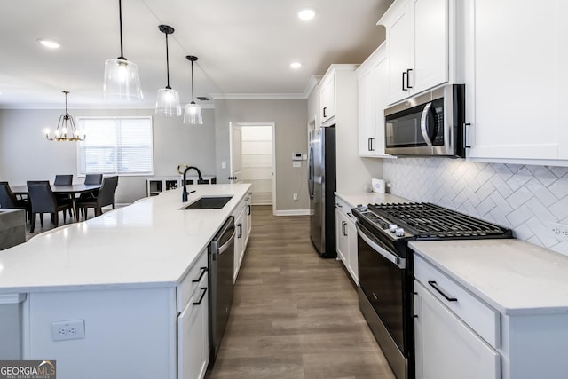 3739 Silvery Way, Powder Springs, GA 30127 - kitchen featuring a kitchen island with sink, a sink, decorative backsplash, appliances with stainless steel finishes, and crown molding