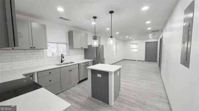 kitchen with visible vents, gray cabinetry, a sink, light wood-style floors, and appliances with stainless steel finishes