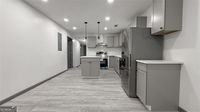 kitchen with stainless steel appliances, gray cabinetry, wall chimney exhaust hood, and decorative backsplash
