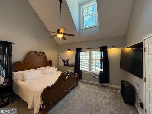 carpeted bedroom with baseboards, high vaulted ceiling, and ceiling fan