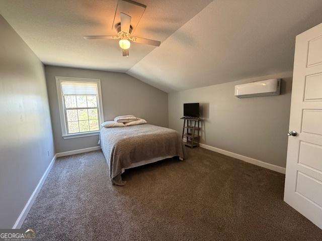 carpeted bedroom featuring lofted ceiling, baseboards, a wall mounted air conditioner, and ceiling fan