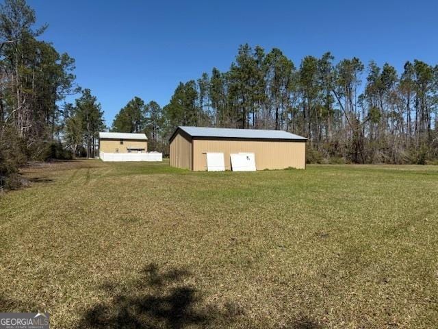 view of yard featuring a detached garage and an outbuilding