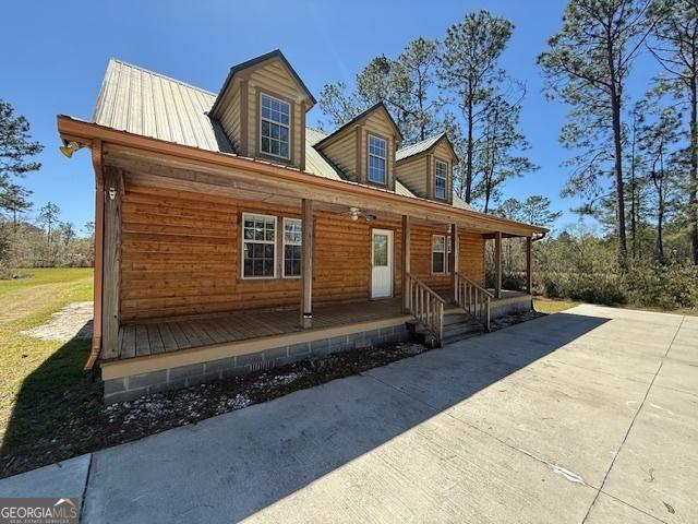 view of front of home featuring metal roof and a porch