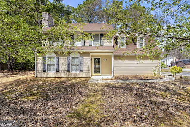 view of front of house with a chimney, a balcony, and a shingled roof