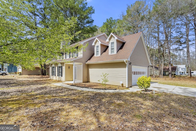 view of front facade featuring roof with shingles and concrete driveway