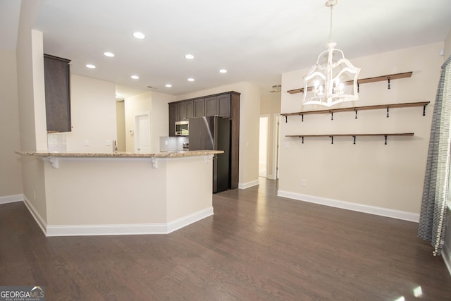 39 Chatham Ct, Williamson, GA 30292 - kitchen with dark wood finished floors, an inviting chandelier, dark brown cabinets, baseboards, and appliances with stainless steel finishes