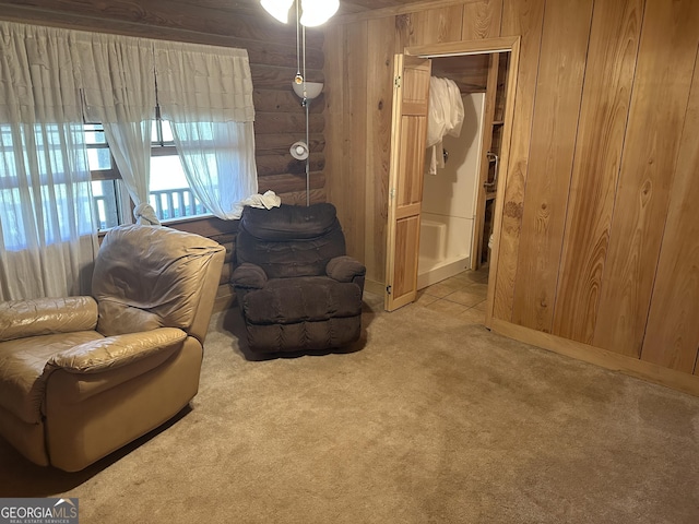 sitting room featuring wood walls and carpet floors