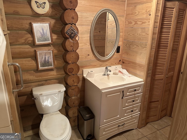 half bathroom featuring tile patterned flooring, toilet, a closet, rustic walls, and vanity