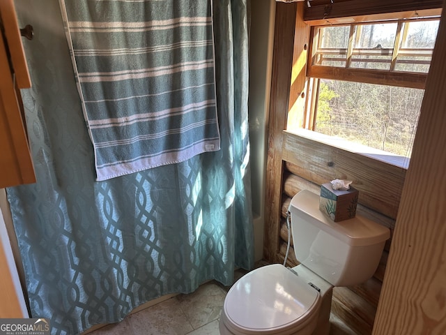 bathroom with curtained shower and toilet
