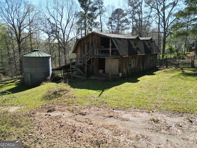 rear view of house with a yard, a gambrel roof, a barn, and an outdoor structure