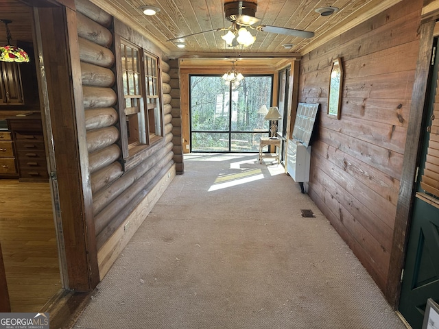 hall featuring rustic walls, a notable chandelier, carpet, and wooden ceiling
