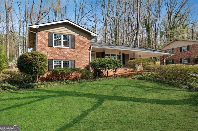 tri-level home featuring a front lawn, a carport, and brick siding