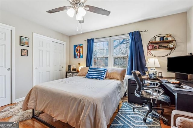 bedroom featuring a ceiling fan, wood finished floors, a closet, and baseboards