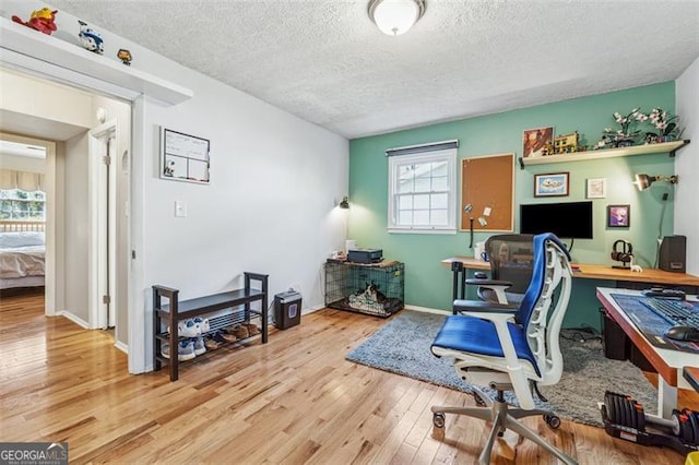 home office featuring baseboards, a textured ceiling, and hardwood / wood-style floors