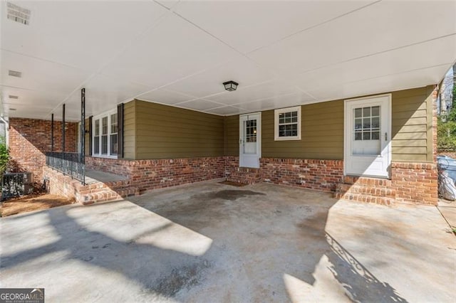 view of patio / terrace featuring entry steps, a carport, and visible vents