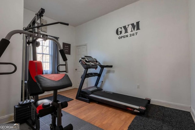 exercise area with baseboards and wood finished floors