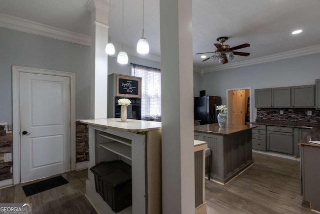 kitchen featuring gray cabinets, ornamental molding, a center island, and freestanding refrigerator