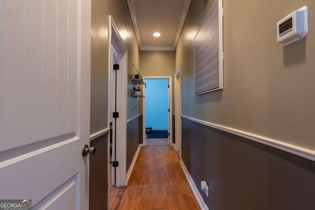 hallway with recessed lighting, wood finished floors, baseboards, and ornamental molding