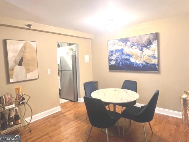 dining space featuring baseboards and wood finished floors
