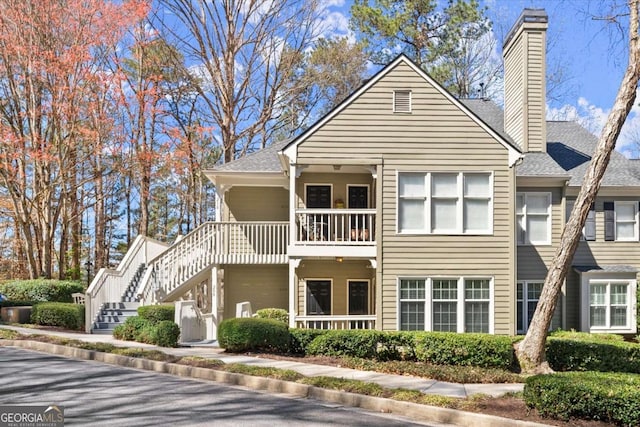 view of front of property featuring stairs and a chimney
