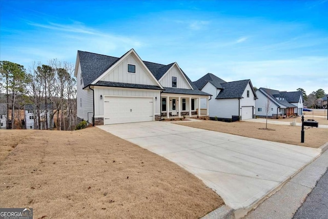 modern inspired farmhouse featuring driveway, stone siding, covered porch, board and batten siding, and roof with shingles