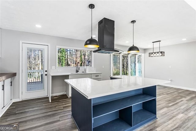 kitchen with recessed lighting, a sink, open shelves, island range hood, and dark wood finished floors