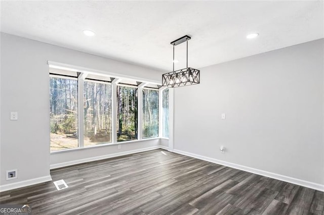 unfurnished dining area featuring dark wood-style flooring, visible vents, recessed lighting, and baseboards