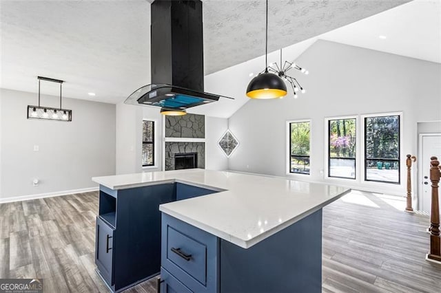 kitchen with light countertops, wood finished floors, open floor plan, and blue cabinetry