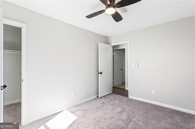 unfurnished bedroom with ceiling fan, a closet, baseboards, and light carpet