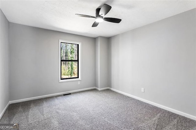 spare room featuring a ceiling fan, visible vents, carpet, baseboards, and a textured ceiling