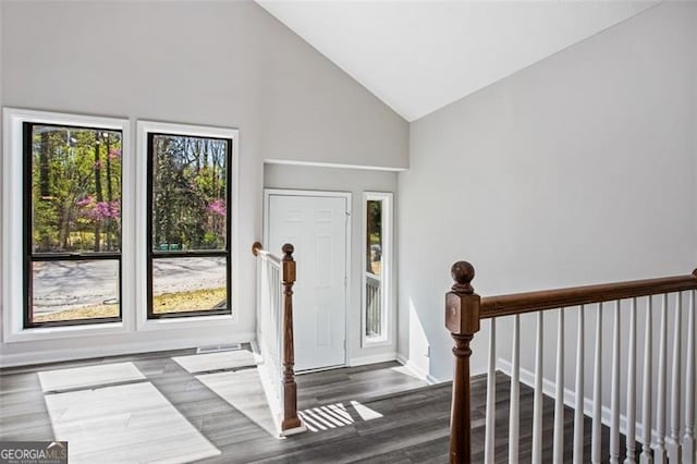 entrance foyer with wood finished floors, high vaulted ceiling, and baseboards