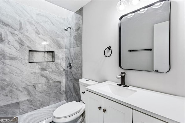 bathroom featuring a shower stall, toilet, and vanity