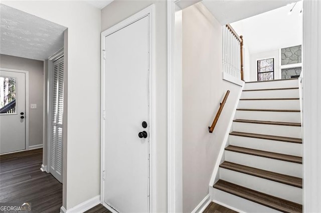 staircase with baseboards, wood finished floors, and plenty of natural light