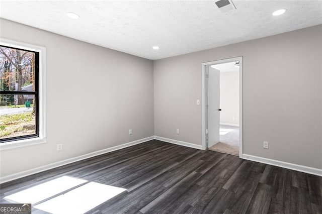 unfurnished room featuring a textured ceiling, visible vents, dark wood-style floors, baseboards, and recessed lighting